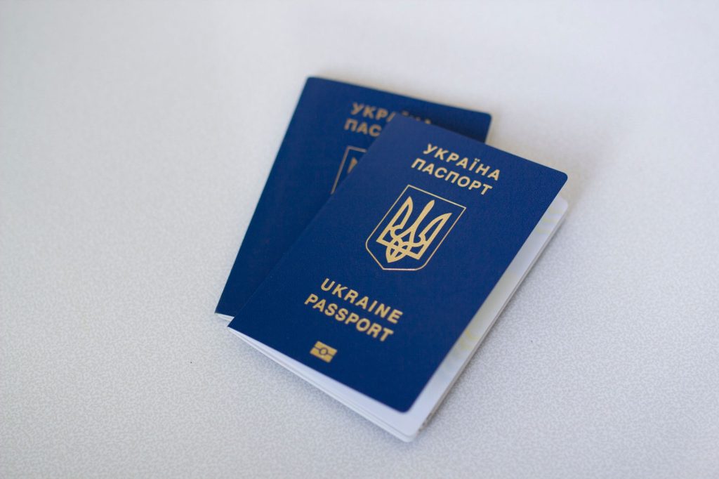 Blue Ukrainian passports on a light surface, highlighting travel documents.